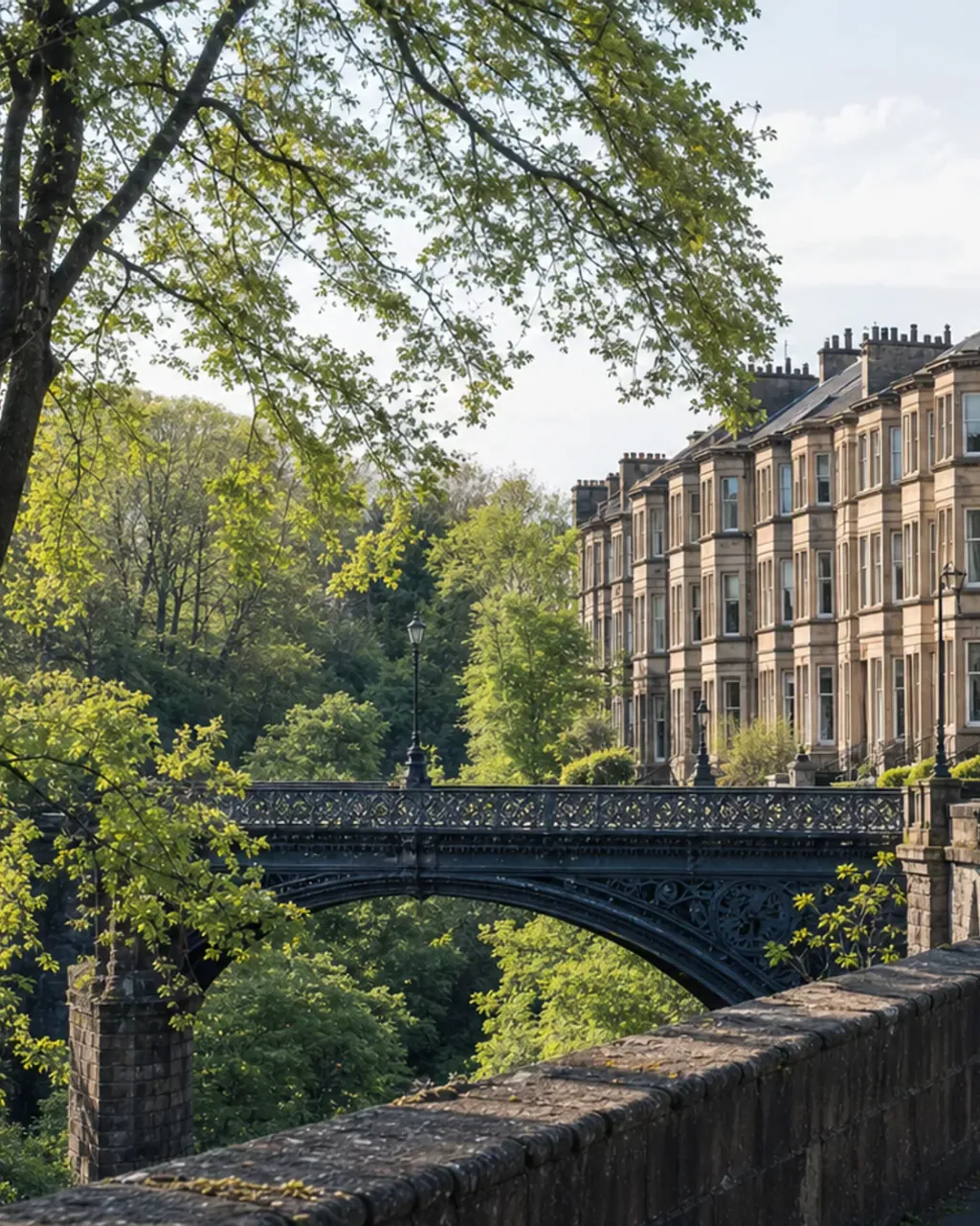 Blond sandstone terraced flats above the wooded Kelvin gorge, with the cast-iron bridge at Kelvinbridge below